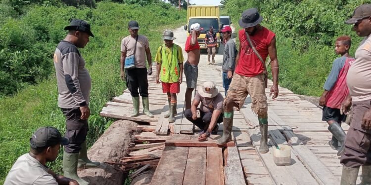 Kapolsek Bonggo Bersama Warga Perbaiki Jembatan Kayu di Kampung Mawes Mukti
