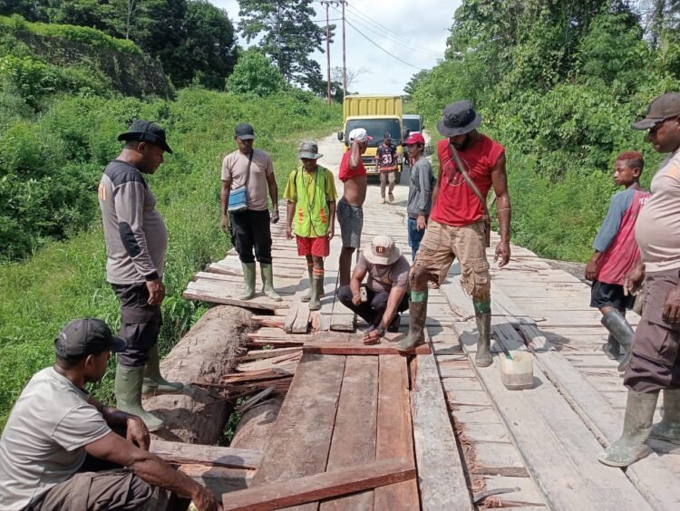 Kapolsek Bonggo Bersama Warga Perbaiki Jembatan Kayu di Kampung Mawes Mukti